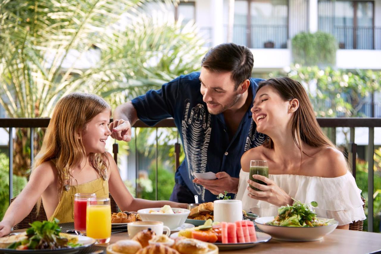 Courtyard By Marriott Bali Seminyak Resort Kültér fotó A family enjoying a meal at the hotel