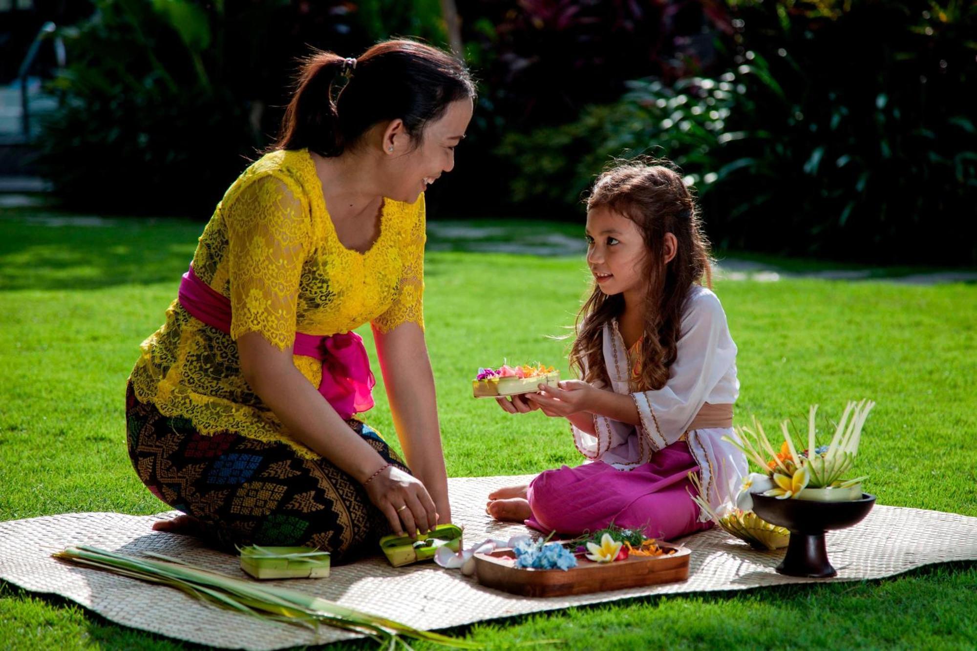 Courtyard By Marriott Bali Seminyak Resort Kültér fotó A Balinese Hindu woman and her daughter preparing offerings.